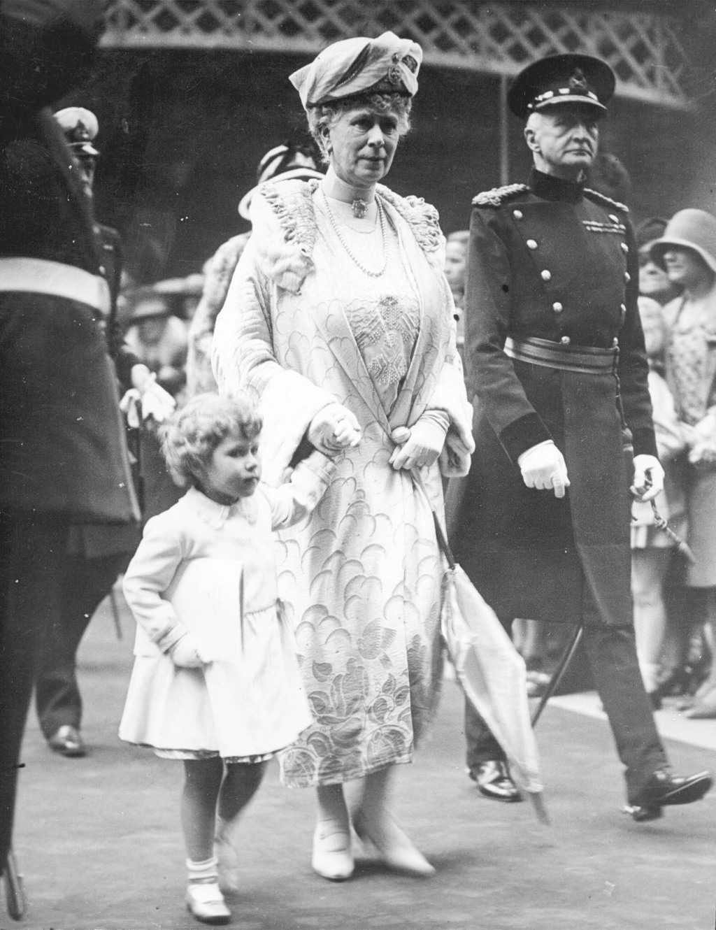 在這張 1930 年 5 月 29 日的資料照片中，當時 4 歲的英國公主伊麗莎白在參加皇家錦標賽的開幕式表演後離開倫敦奧林匹亞車站時，緊握著祖母瑪麗王后的手。（美聯社）