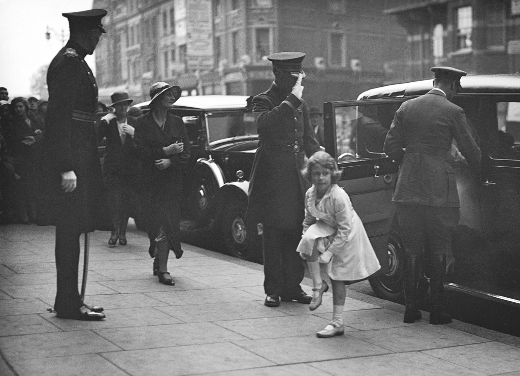 在這張 1933 年 5 月 30 日的檔案照片中，英國伊麗莎白公主在抵達倫敦奧林匹亞時正在調整她的襪子。（美聯社）