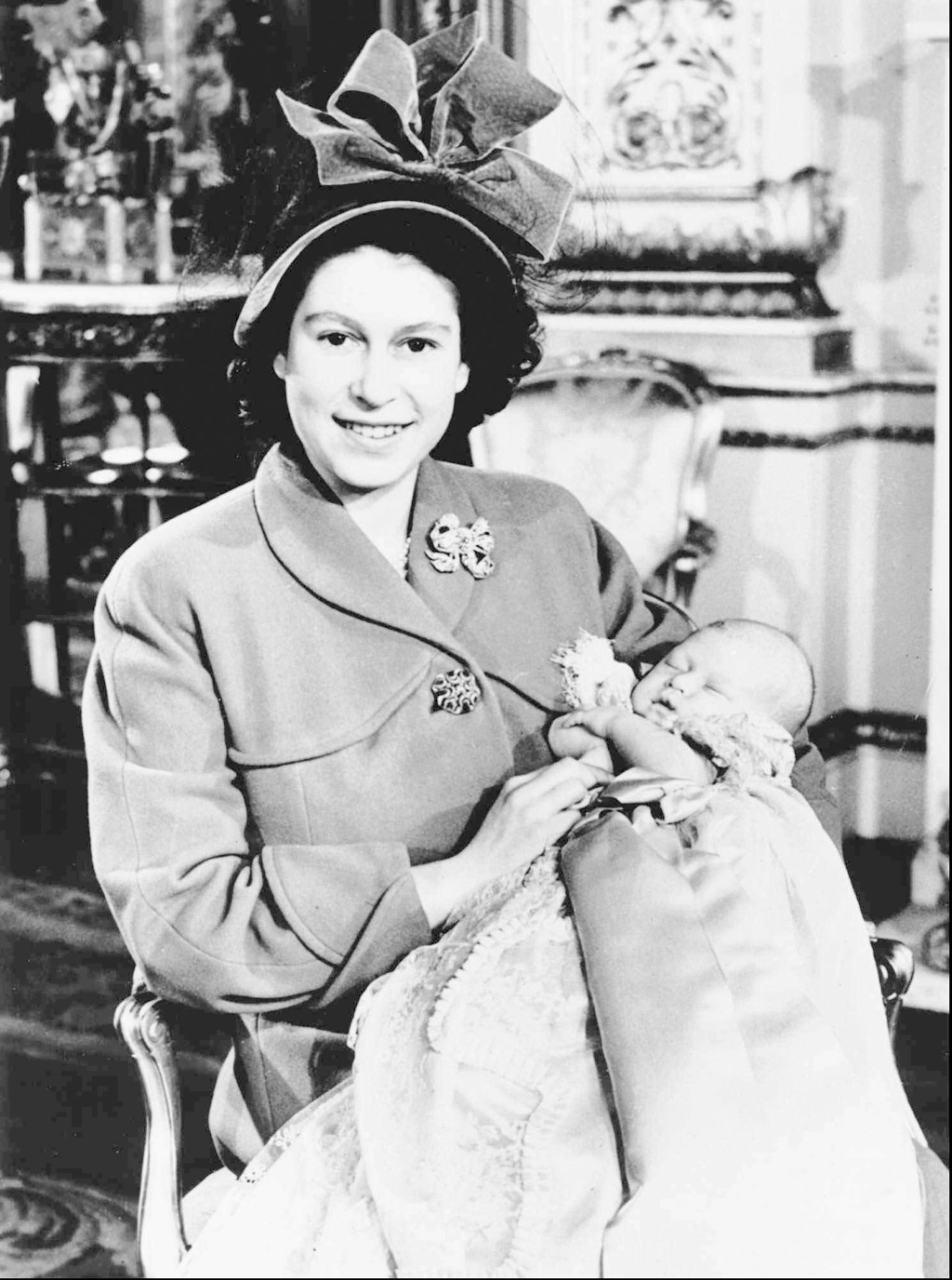 1948年12月，英國伊麗莎白公主與她的長子查爾斯王子在倫敦受洗後在白金漢宮合影。（美聯社）