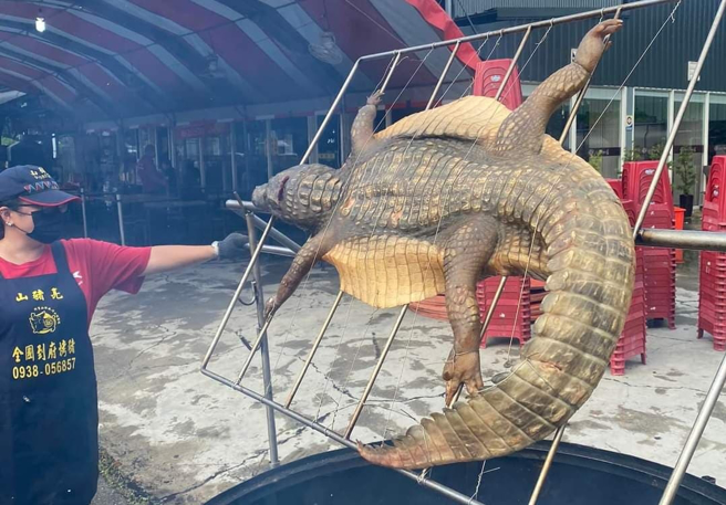 嘉义一处瓮仔鸡店家日前被发现在店外烤「整只鱷鱼」，只见鱷鱼被剖开，超大身躯摆在火炉上烘烤，让网友喊「霸气啊」。（翻摄自脸书「嘉义多一点」）