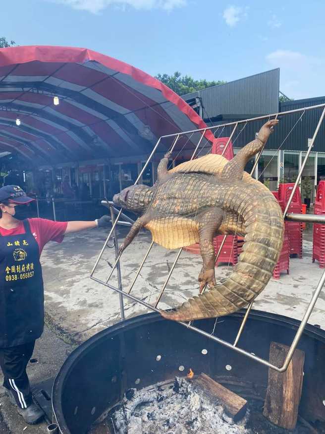 嘉义一处瓮仔鸡店家日前被发现在店外烤「整只鱷鱼」，只见鱷鱼被剖开，超大身躯摆在火炉上烘烤，让网友喊「霸气啊」。（翻摄自脸书「嘉义多一点」）