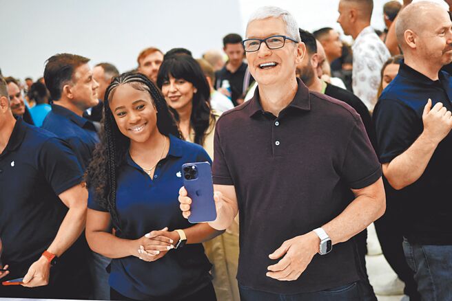 2022苹果秋季发表会在昨晚举行，苹果执行长库克开心拿着新款iPhone。（路透）