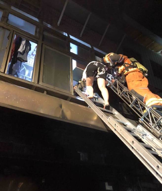 消防人員從2樓救出2男2女意識清楚送醫治療。（翻攝畫面／蔡明亘桃園傳真）