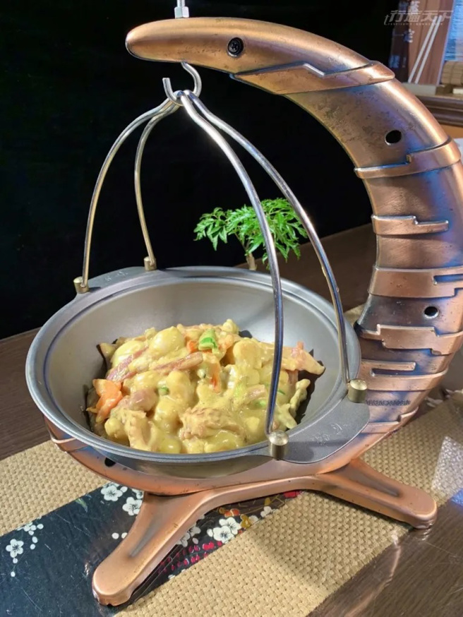 阿丰师餐厅招牌料理「法式炒双鲜」以弦月造型餐盘装盛，将花枝、鱿鱼快炒后加上椰奶和咖哩调制的法式酱汁调味，香气口感都迷人。（图/ 行遍天下）