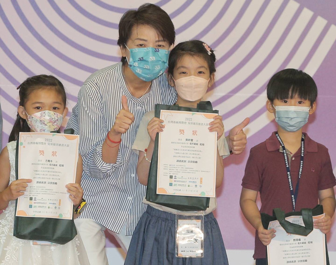 无党籍台北市长参选人黄珊珊（后）10日出席「2022儿童慈善绘画大赏」颁奖典礼，担任颁奖人并和得奖小朋友合影留念。（赵双杰摄）