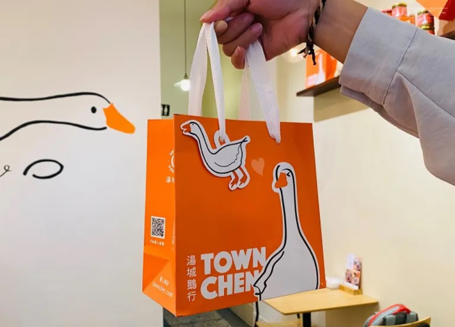 選用鵝身上的橘白雙色為主色調，品牌整體到菜單、文宣包裝設計都用心。（圖/ 行遍天下）