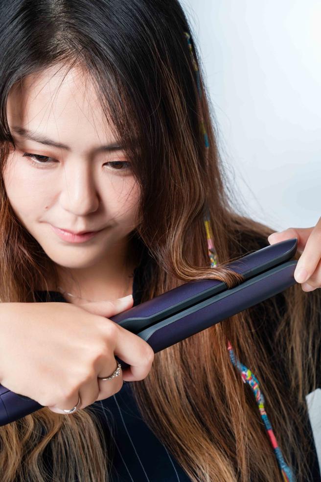 使用飞利浦温控护色水润直卷两用负离子美髮造型器打造人鱼卷造型时，可使用边前后翻转造型器、边往下移的手法。（石智中摄）