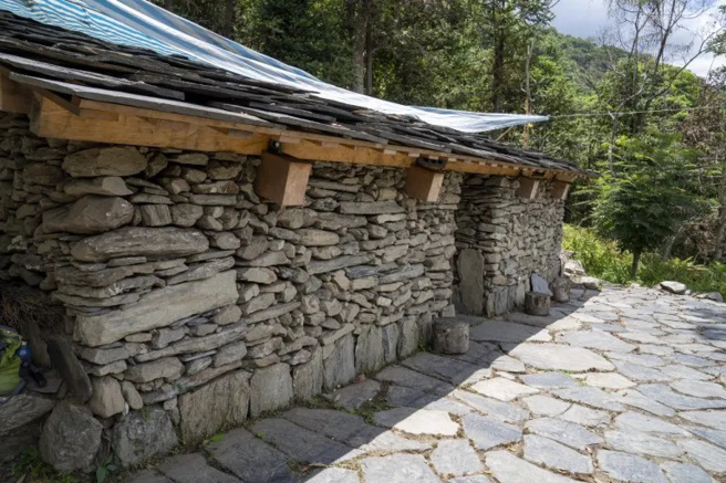 布农族人寻根过程找到荒废损毁的遗构，经各方协助依照片重建的石板屋。（图/ 行遍天下）