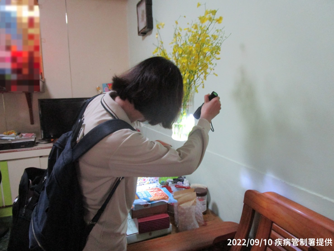 防疫人员于高雄市前镇区执行孳生源查核，协助民眾检视家中花瓶等容器内是否有孑孓或蚊卵。(疾病管制署提供)