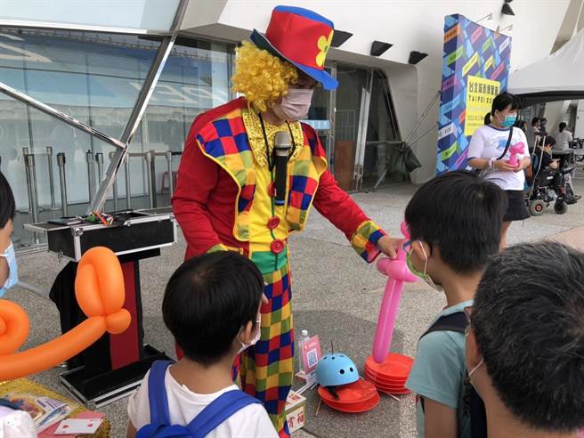 街头艺人在花博场馆外表演折气球，与孩子互动。（张芷瑜摄）