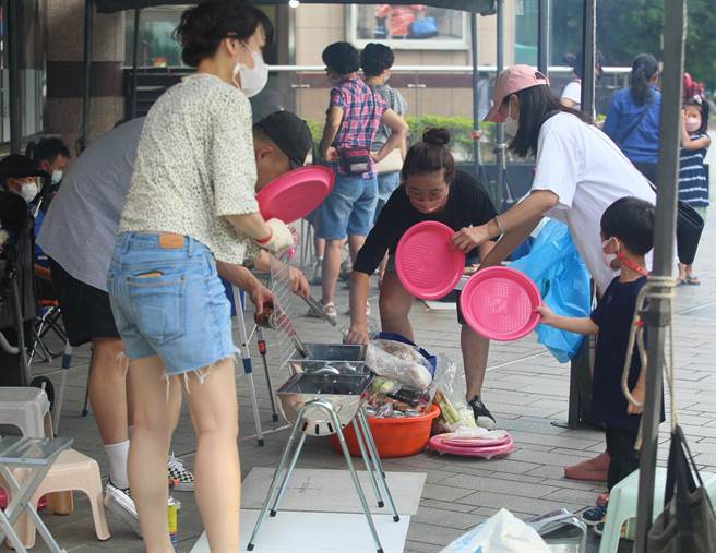 天母幫2022年百人大會烤10日晚間在大葉高島屋百貨前廣場舉行，圖為民眾全家努力搧風生火。（張鎧乙攝）