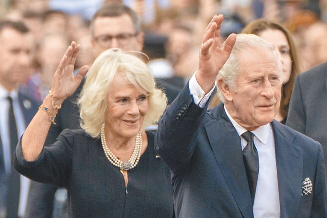 待位70年终于等到王位的英王查尔斯三世（前右）和王后卡蜜拉，9日在白金汉宫外向群眾挥手致意，民眾也高呼「天佑国王」(God save the King)。（美联社）