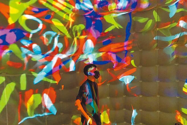 民眾欣赏「烟花宇宙数位音像工作室」利用创办人的画作改制成影像，再搭配实验声响混制的作品《诙谐 A Joke》。（新北市文化局提供／陈慰慈新北传真）