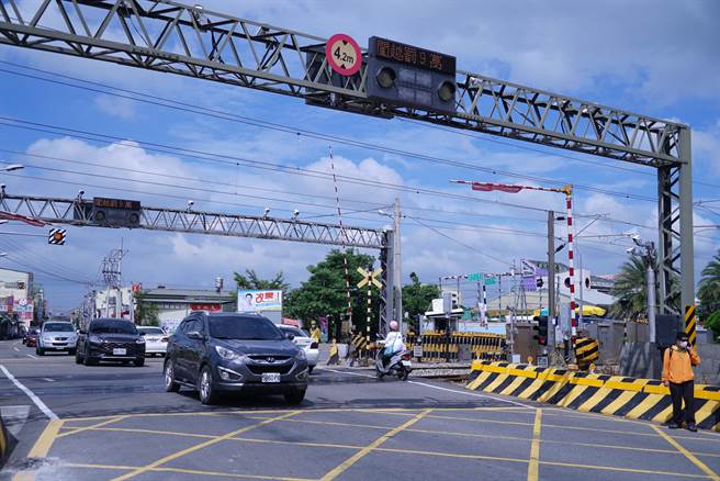 火车经过栅栏升起，车辆恢復通行。（吴建辉摄）