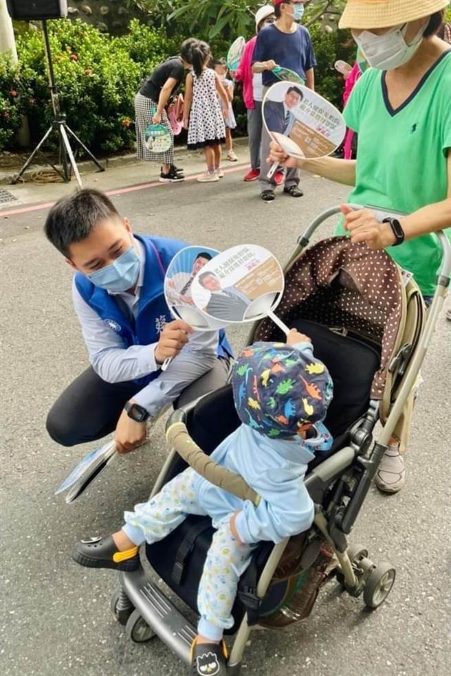 第八选区国民党市议员参选人蔡宗豪(左)发扇子给乡亲。(蔡宗豪提供／曹婷婷台南传真)