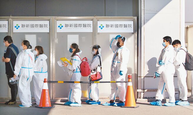 中央流行疫情指揮中心10日公布國內新增35594例本土個案及236例境外移入。在桃園機場第一航廈外的採檢站，剛下機的旅客正在排隊採檢。（范揚光攝）