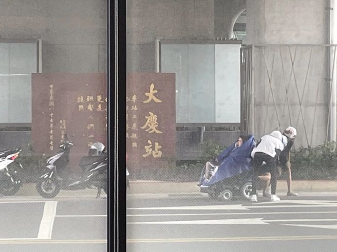 3名年轻人在路边替轮椅伯穿雨衣。（图／翻摄自爆料公社）
