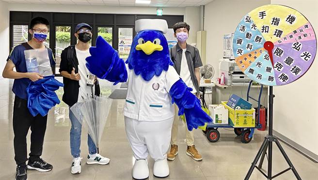 参加活动的学生开心与穿着护理师服装，学校吉祥物弘光猎鹰拍照。（弘光科大提供）