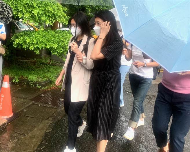 黃嘉千（黑色洋裝）出庭前緊抓律師的手臂。（李文正攝）