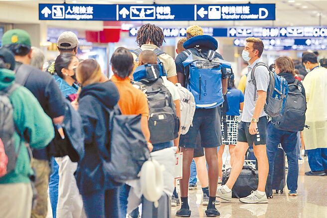 中央流行疫情指揮中心表示，根據預估疫情尚未達到高峰，11日確診數降，應是假日效應所致。圖為桃園機場入境的外國旅客。（陳麒全攝）