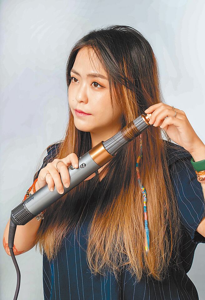 在髮丝中间放上Airwrap髮卷，再把髮尾轻卷上造型器上即会自动吸住头髮，来回拉动让髮丝更能吸附在Airwrap上，手扶着顶端，维持大概8-10秒，即可定型。（石智中摄）