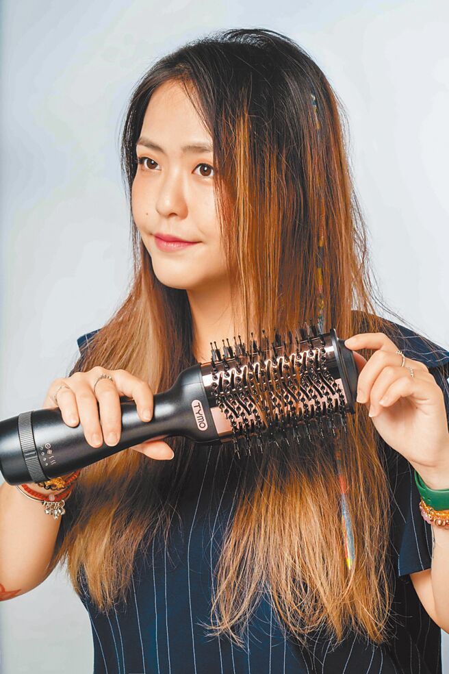 使用TYMO VOLUMIZER负离子热风梳时，可一手扶着髮尾卷进造型器的齿梳中，最后稍微往前拉，打造滑顺又有弧度的直髮造型。（石智中摄）