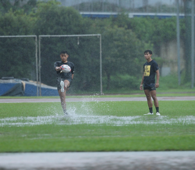 中颱梅花持续向北移动，外围环流带来阵雨笼罩北台湾，台师大橄榄球队员则利用这波阵雨，训练雨中踢球的技巧。（陈怡诚摄）