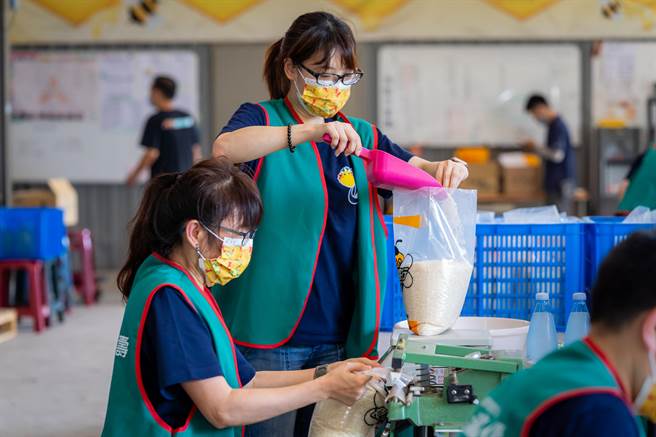 台壽志工合作無間，封裝完成一袋袋白米。（台壽提供）