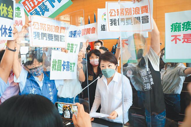 台中狼师案昨在市议会引发口水战，蓝、绿议员高举手拿板，挤在市长卢秀燕周边互呛。（林欣仪摄）