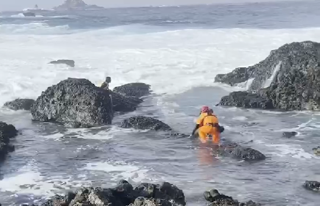 民眾於颱風期間觀浪，海巡人員腿部遭割傷。(記者爆料網提供)
