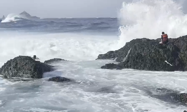 民眾遭大浪襲擊落海受困礁岩區。(記者爆料網提供)
