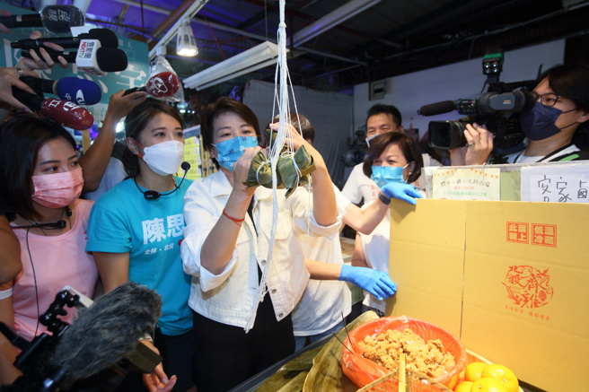 無黨籍台北市長參選人黃珊珊（中）14日由民眾黨士林北投區議員參選人黃瀞瑩（左一）、陳思宇（左二）陪同下，前往北投市場掃街拜票，有攤商熱烈歡迎，邀請黃一起包粽子，期許她包中高升。（張鎧乙攝）