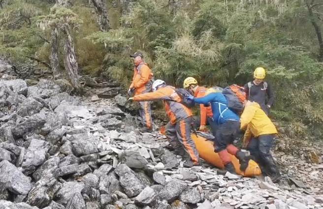 搜救人员将陈姓法官遗体妥善打包合力搬运，因现场岩石陡峭加上落差大，天然地形不利行走，救难人员在搬运移动上难度很高。（陈世宗翻摄）