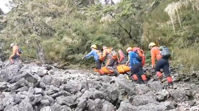 搜救人员将陈姓法官遗体妥善打包合力搬运，因现场岩石陡峭加上落差大，天然地形不利行走，救难人员在搬运移动上难度很高。（陈世宗翻摄）