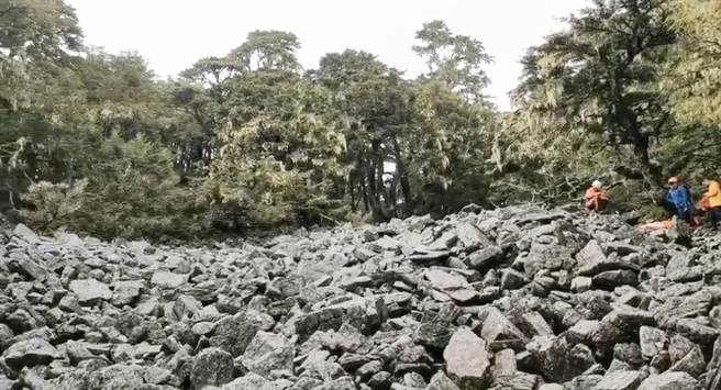 消防局第二大队长余易佑说，目前已将陈先生搬运至可以执行吊挂的区域，但因山上云层太厚，经评估无法执行吊挂作业。（陈世宗翻摄）