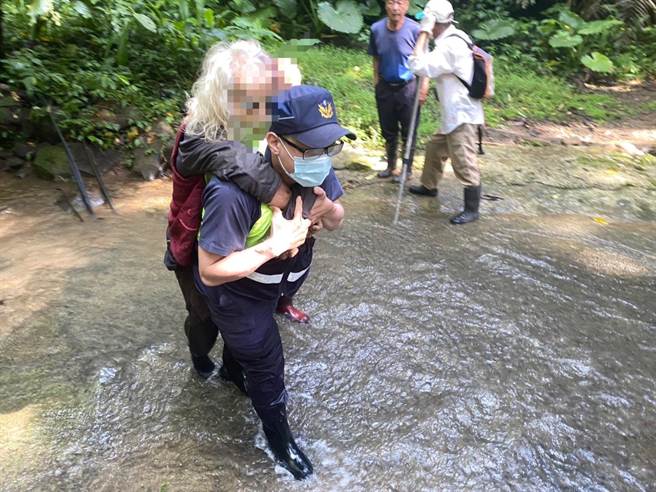 头份警分局蓬莱所员警背负受伤的黄姓老翁脱困送医。（头份警分局提供／谢明俊苗栗传真）