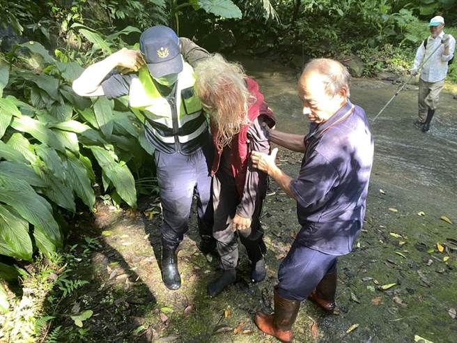 头份警分局蓬莱所员警背负受伤的黄姓老翁脱困送医。（头份警分局提供／谢明俊苗栗传真）