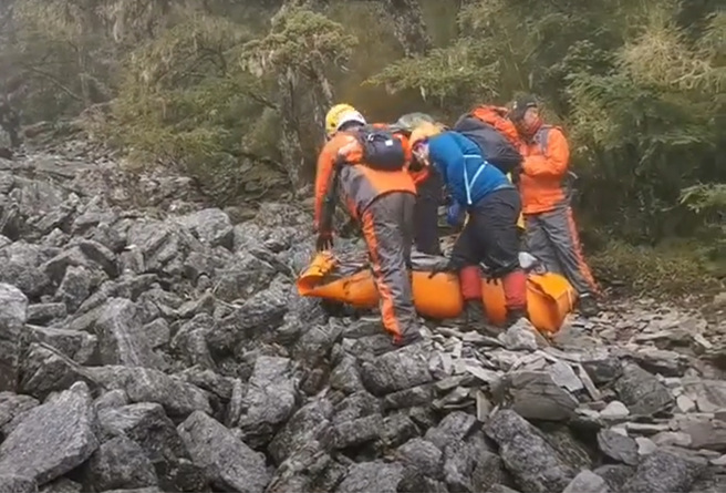 目前已將陳伯均搬運至可以執行吊掛的區域，但因山上雲層太厚，經評估無法執行吊掛作業。（翻攝自影片）