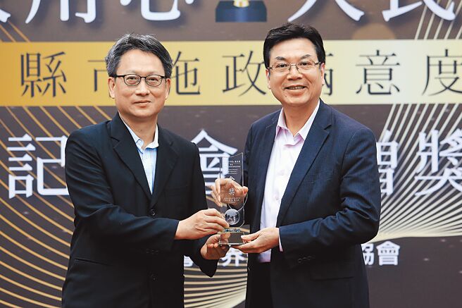 台湾世界新闻传播协会14日举办全国县市施政满意度调查发布记者会暨赠奖典礼，新北市在六都首长满意度夺下金奖，新北市副市长刘和然（右）从台湾世界新闻传播协会会长刘立汉（左）手中接过奖座。（黄世麒摄）