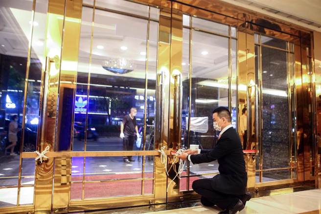 位于北市东区、已有20余年歷史的「台北神旺大饭店」，15日晚结束营业，熄灯后，饭店人员关上20几年从未关上的大门。（邓博仁摄）