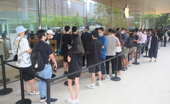 蘋果直營店16日開賣iPhone 14，但僅提供官網預購民眾取貨，8點開門前店外依舊出現排隊人潮。（張鎧乙攝）