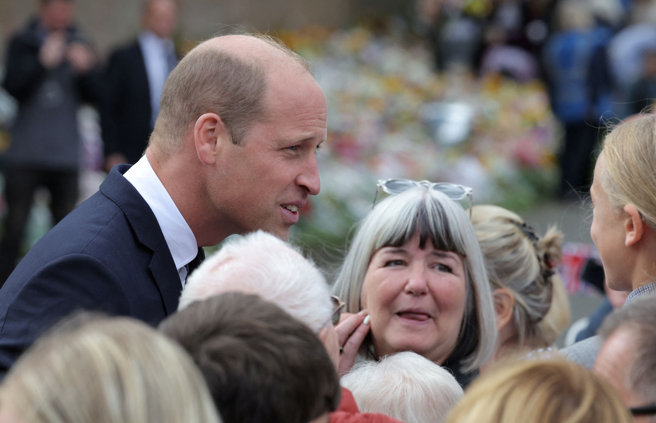英国威尔斯亲王威廉9月15日和齐聚山均汉姆庄园（Sandringham House）诺维奇门（Norwich Gates）外的悼念民眾交谈。（路透）