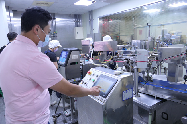 「澎富企业」蔡瑞富严谨检视调理包封装设备的每个流程。(照片/醒吾科大提供)