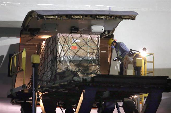 貨機停靠機坪後地勤人員卸下裝載疫苗的貨盤。（范揚光攝）