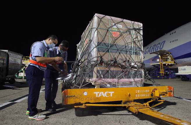 海關人員在機邊查驗裝載疫苗的貨盤。（范揚光攝）