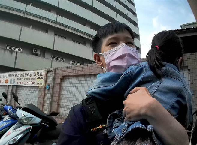 员警看到泪眼汪汪、手足无措的女童，便一把抱起，往台湾银行走去，并沿路安抚女童「不哭不哭，眼泪是珍珠」。（高市凤山分局提供／杨舒婷高雄传真）