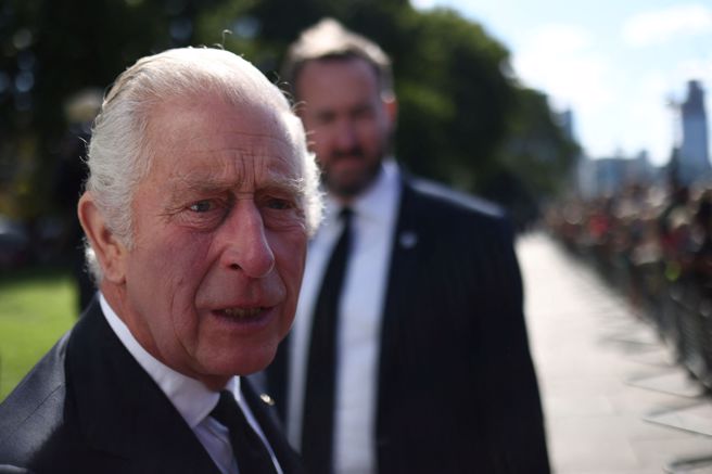 王室记者还原了查尔斯国王当时接获噩耗的场景，图为女王驾崩后，他至外头与排队瞻仰英女王灵柩的民眾寒暄。(图/路透社)