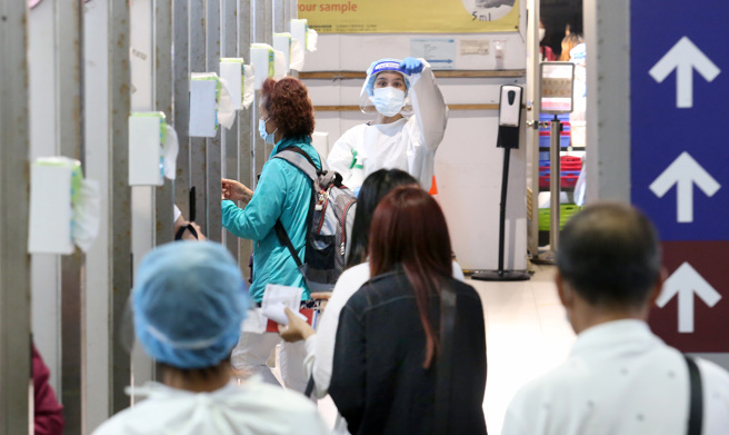 指挥中心公布今日本土确诊数。图为桃园机场刚入境的旅客待採检照。（图／记者范扬光摄影）