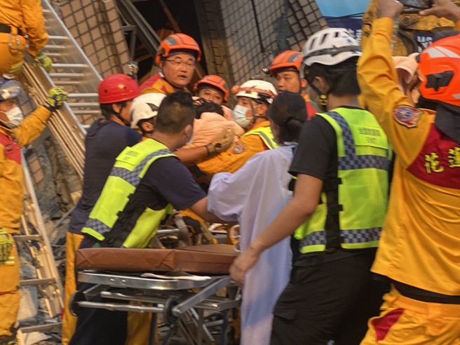 玉里楼倒母女受困「打手机与父通话」，已定位待救援，受困5岁覃小妹救出。（罗亦晽摄）