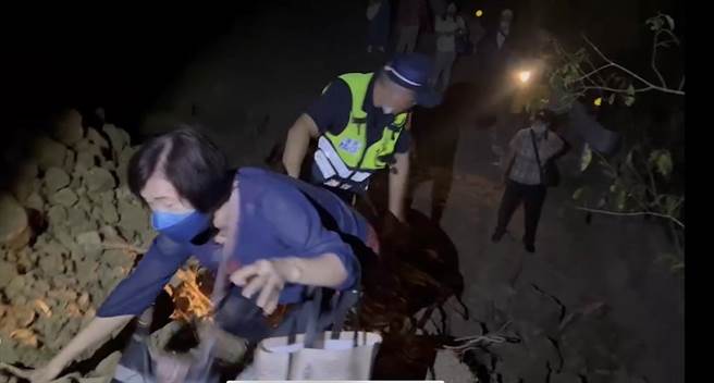 六十石山受困民眾，由警方一一接駁，越過土堆。（民眾提供）
